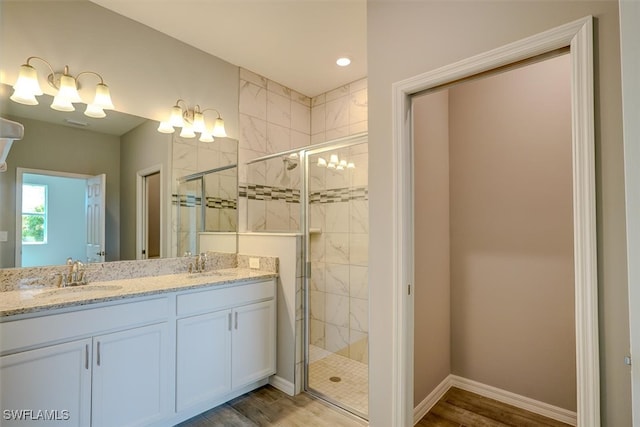 bathroom featuring vanity, hardwood / wood-style flooring, and a shower with shower door