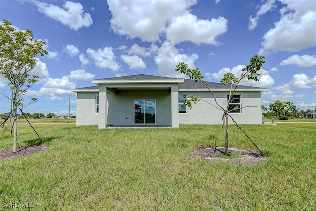 rear view of house featuring a lawn