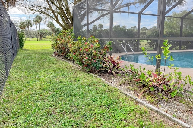 view of swimming pool with glass enclosure and a yard