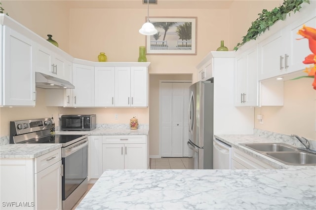 kitchen featuring appliances with stainless steel finishes, light tile patterned flooring, white cabinetry, pendant lighting, and sink