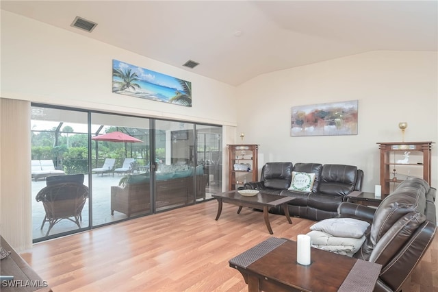 living room with vaulted ceiling and light hardwood / wood-style floors