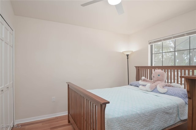 bedroom featuring light hardwood / wood-style floors, ceiling fan, and a closet