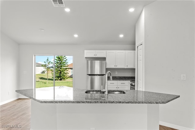 kitchen with white cabinets, appliances with stainless steel finishes, light hardwood / wood-style flooring, and sink