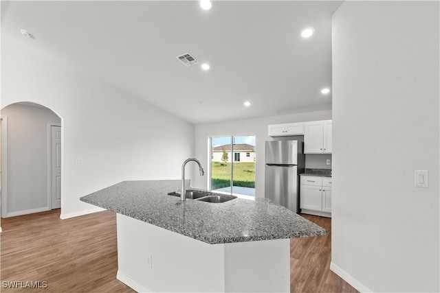 kitchen featuring white cabinets, stainless steel fridge, sink, and light hardwood / wood-style flooring