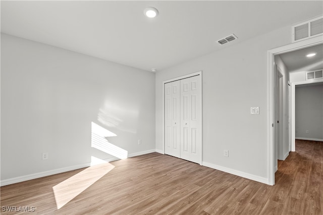 unfurnished bedroom featuring hardwood / wood-style flooring and a closet