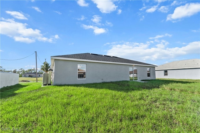 rear view of property featuring a yard