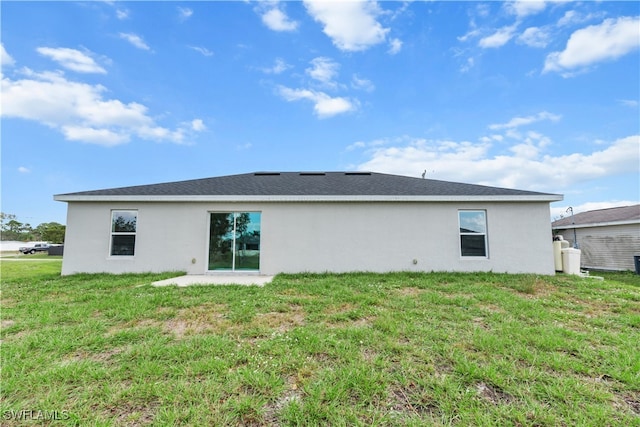 rear view of house with a patio and a yard