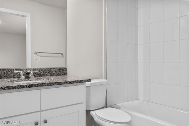 full bathroom with vanity, tiled shower / bath combo, and toilet