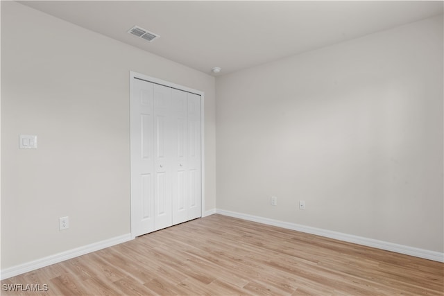 unfurnished bedroom featuring light hardwood / wood-style flooring and a closet