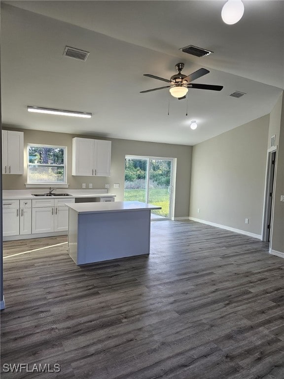 1034 Pilgrim St E, Lehigh Acres, FL 33974 - kitchen featuring a kitchen island, a ceiling fan, white cabinets, light countertops, and dark wood-style flooring