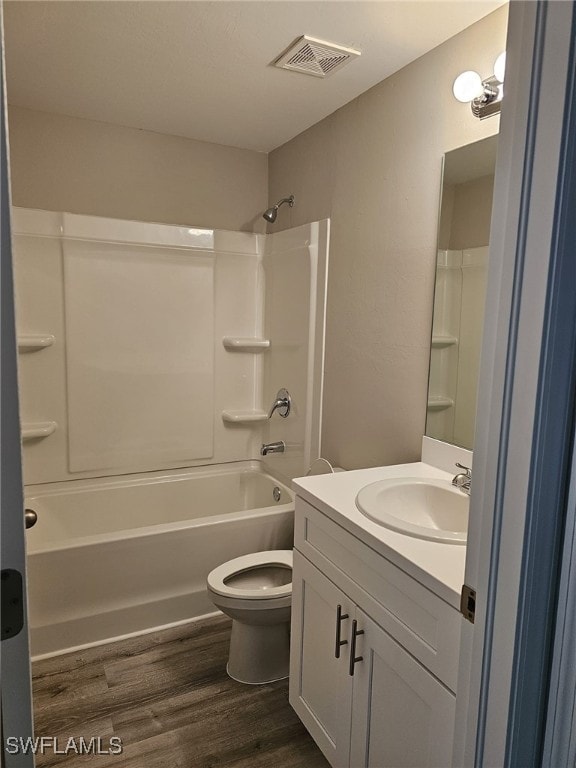 full bathroom with bathtub / shower combination, wood-type flooring, vanity, and toilet