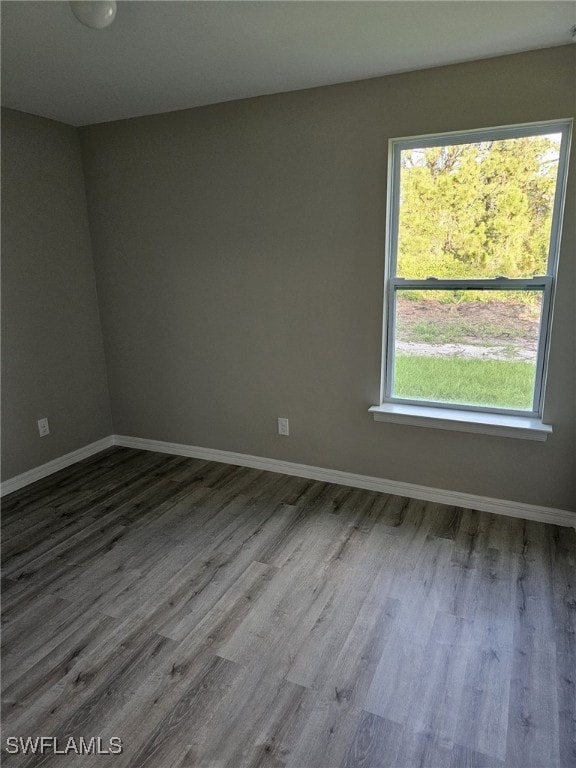 1034 Pilgrim St E, Lehigh Acres, FL 33974 - spare room featuring wood finished floors and baseboards