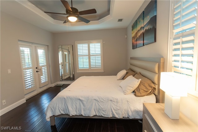 bedroom featuring access to exterior, dark hardwood / wood-style flooring, multiple windows, and ceiling fan