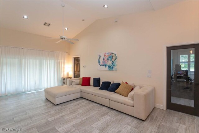 living room featuring ceiling fan, light hardwood / wood-style flooring, and high vaulted ceiling