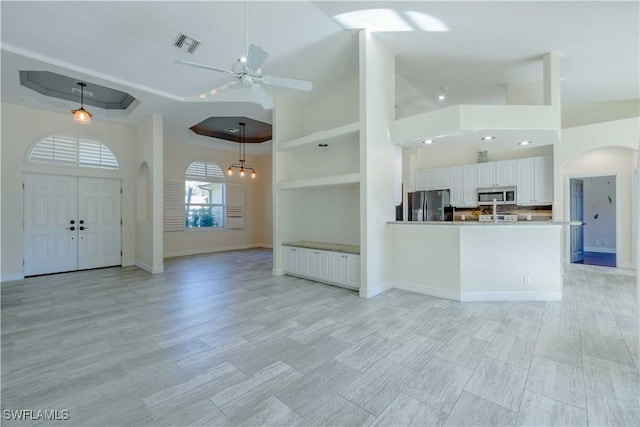 20730 Groveline Ct, Estero, FL 33928 - kitchen with stainless steel appliances, arched walkways, open floor plan, ceiling fan, and a towering ceiling