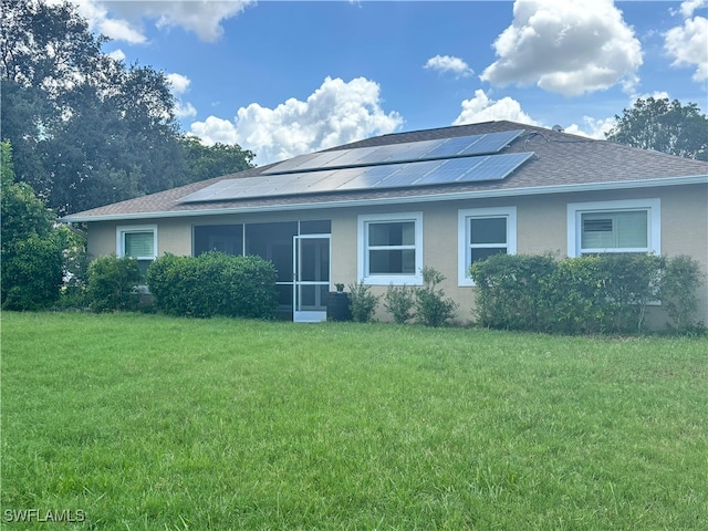 20730 Groveline Ct, Estero, FL 33928 - view of front of house featuring roof mounted solar panels, stucco siding, a front lawn, and roof with shingles