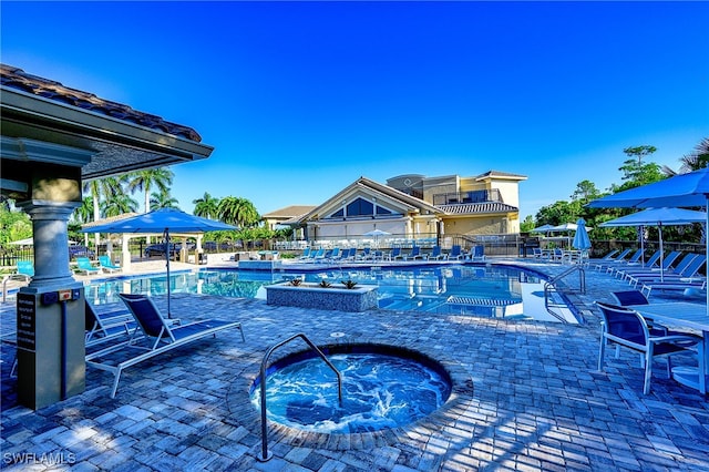 view of swimming pool with a patio and a hot tub