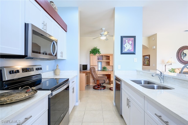 kitchen featuring white cabinets, sink, ceiling fan, light tile patterned floors, and appliances with stainless steel finishes