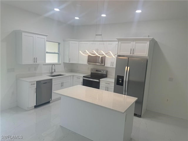 kitchen with white cabinets, stainless steel appliances, sink, and a kitchen island