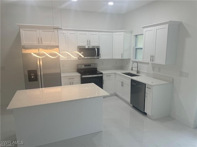 kitchen with stainless steel appliances, white cabinets, a center island, and sink