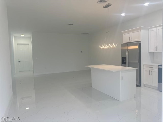 kitchen with pendant lighting, white cabinets, a kitchen island, and stainless steel fridge with ice dispenser