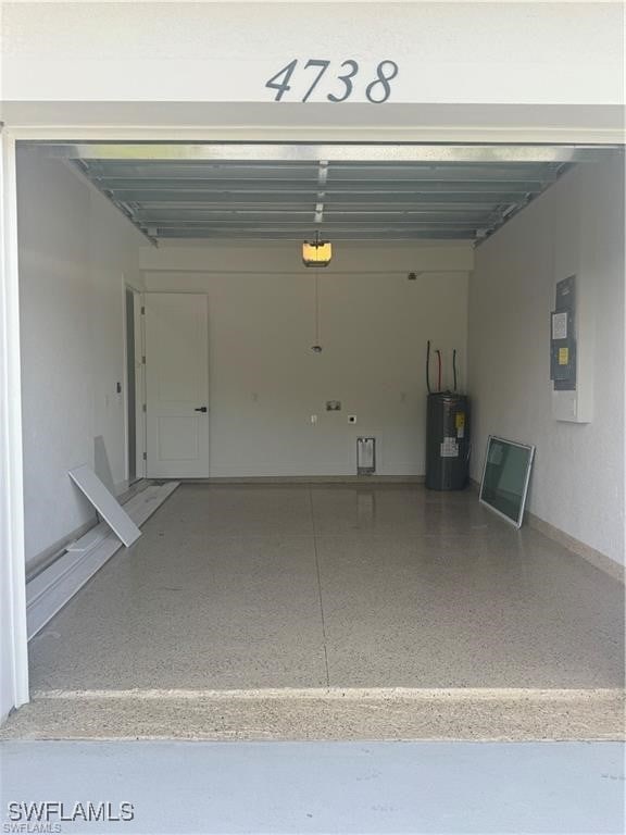 garage with a garage door opener, water heater, and electric panel