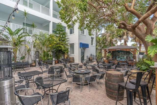 view of patio featuring a gazebo, a balcony, and an outdoor fire pit