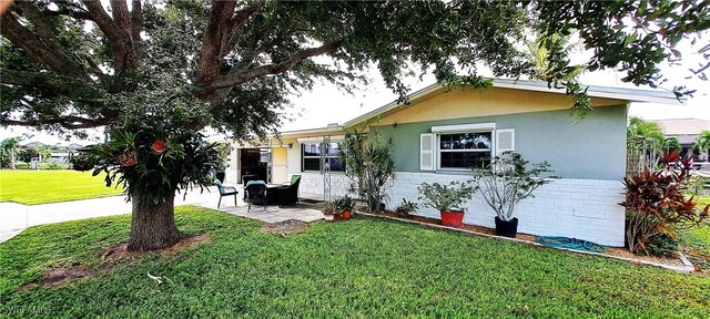 view of front of home featuring a patio and a front lawn