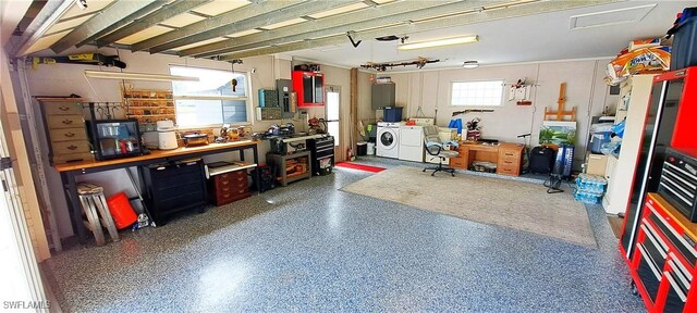 garage featuring washer and dryer and a workshop area