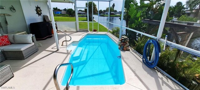 view of pool with a water view and a patio area