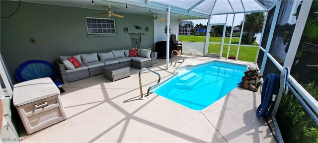 view of pool featuring outdoor lounge area, a yard, glass enclosure, and a patio area