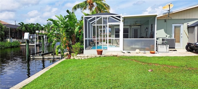 exterior space with glass enclosure, a yard, ceiling fan, a water view, and central air condition unit