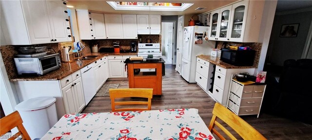 kitchen with white cabinetry, a kitchen island, sink, and white appliances