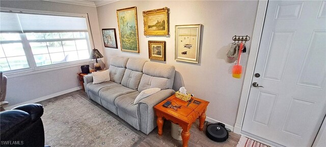 sitting room featuring ornamental molding and light wood-type flooring