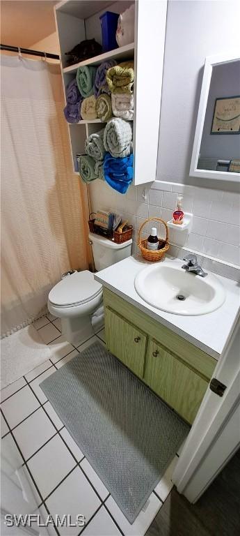 bathroom with toilet, tasteful backsplash, a shower with curtain, vanity, and tile patterned flooring