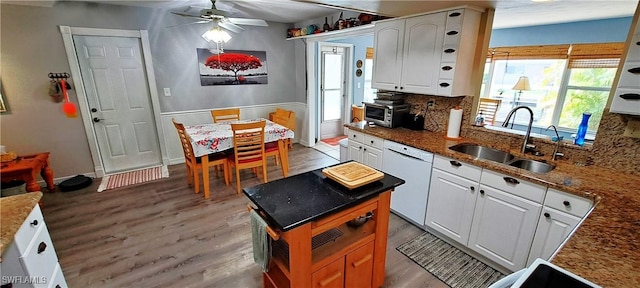 kitchen with sink, dishwasher, white cabinetry, backsplash, and plenty of natural light