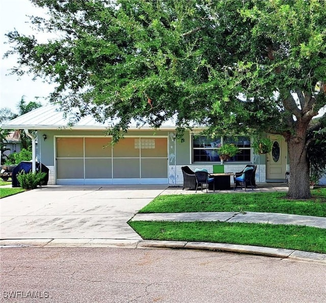 view of front facade featuring a garage, concrete driveway, a front lawn, and stucco siding