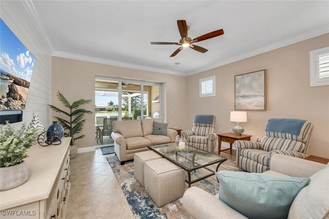 living area with ornamental molding, a ceiling fan, baseboards, and light tile patterned floors