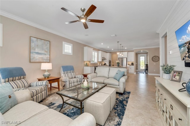 living area with arched walkways, ceiling fan, recessed lighting, baseboards, and crown molding