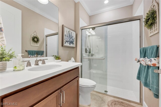 bathroom featuring toilet, vanity, ornamental molding, a shower stall, and tile patterned floors