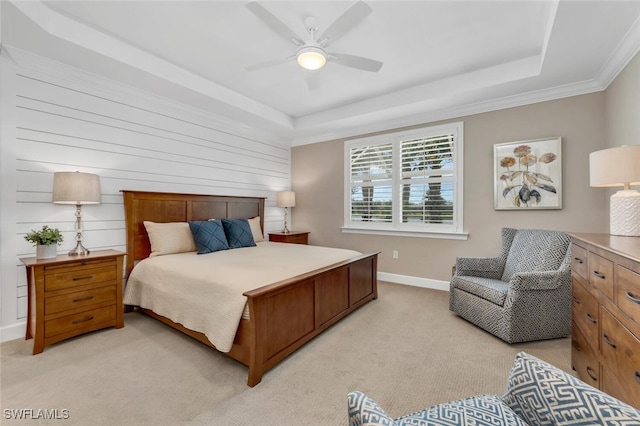 bedroom featuring a ceiling fan, a tray ceiling, light carpet, and baseboards