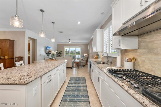 kitchen featuring appliances with stainless steel finishes, white cabinets, a kitchen island, a sink, and under cabinet range hood