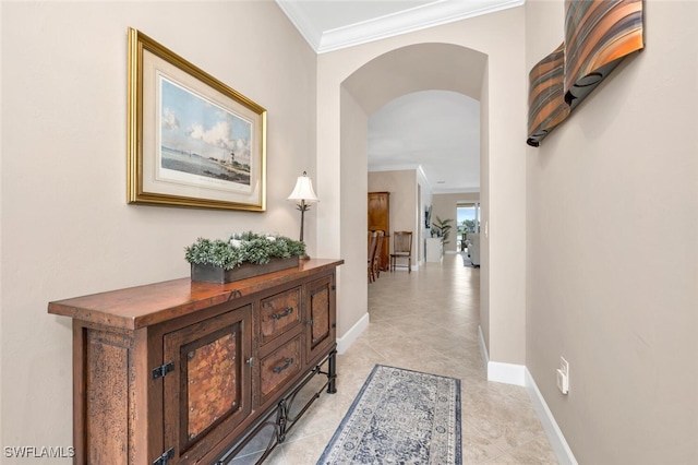 hall with arched walkways, baseboards, and crown molding