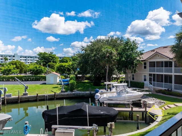 view of dock with a lawn and a water view