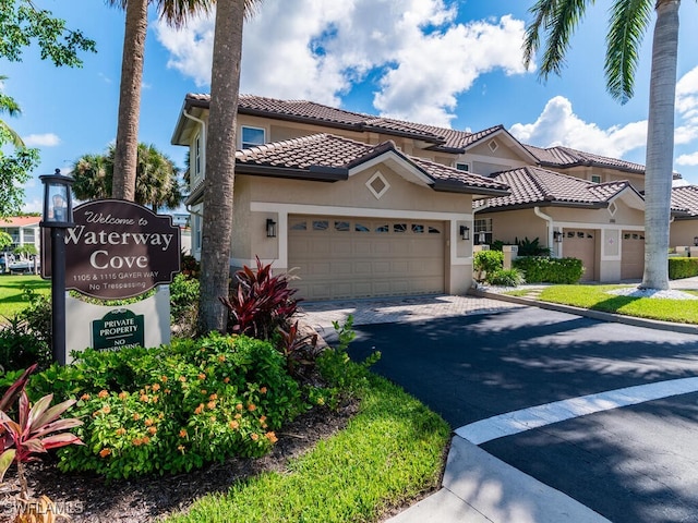 1105 Gayer Way Unit A-202, Marco Island, FL 34145 - mediterranean / spanish-style home featuring stucco siding, driveway, a garage, and a tiled roof