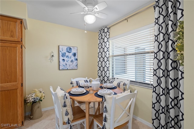 dining space with light tile patterned floors and ceiling fan