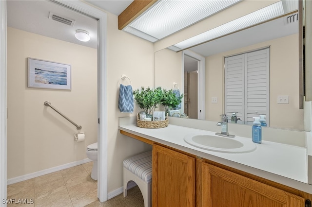 bathroom featuring vanity, tile patterned flooring, and toilet