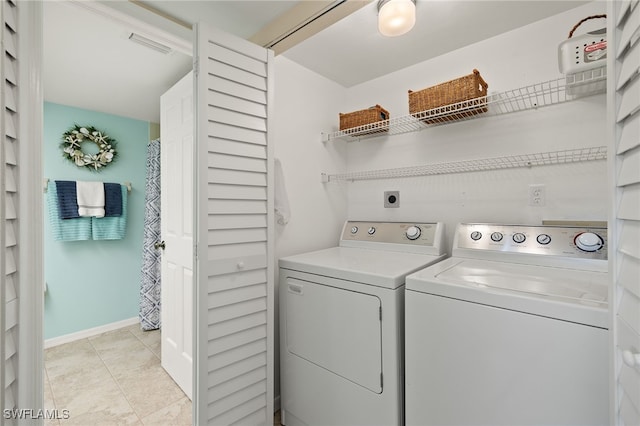 laundry room featuring washing machine and clothes dryer and light tile patterned flooring