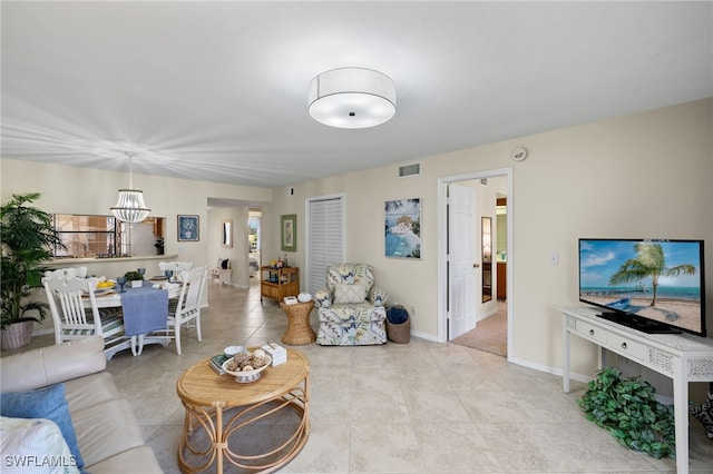 tiled living room with a notable chandelier