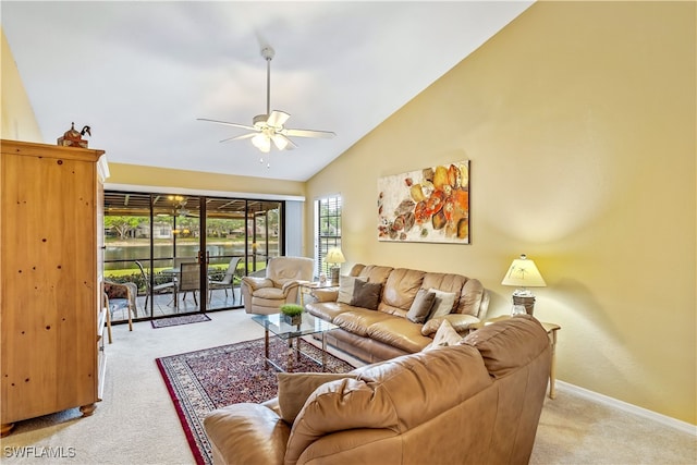 carpeted living room with ceiling fan and high vaulted ceiling